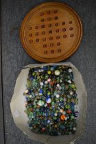 A large quantity of marbles together with a solitaire board.
