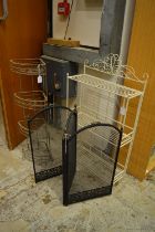 Two wrought iron stands and a folding spark guard.