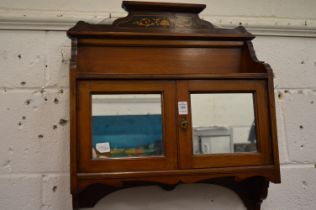 A mahogany hanging bathroom cabinet with pair of mirrored doors.