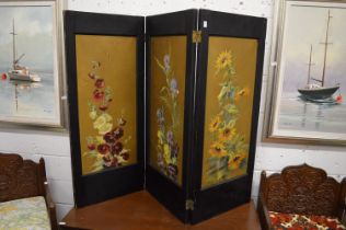 A late Victorian ebonised framed three panelled dressing screen, the panels painted with flowers.