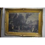 A large gilt framed colour print depicting figures merry making in a village setting.