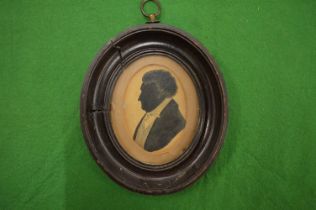 A Victorian oval framed silhouette of a man.