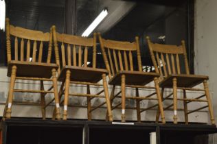 A set of four hardwood kitchen chairs.