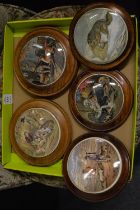 A group of five pot lids, all framed.