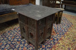 An Eastern carved wood square shaped occasional table with folding base.