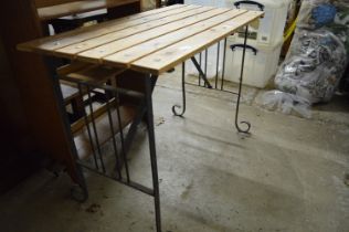 A wrought iron and pine garden table.