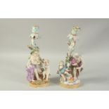 A PAIR OF MEISSEN CANDLESTICKS depicting winter and spring. 29cm high. Cross swords mark in blue.