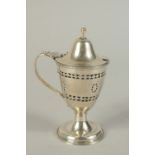 A GEORGE III SILVER MUSTARD POT with sapphire blue liner. Marks rubbed.