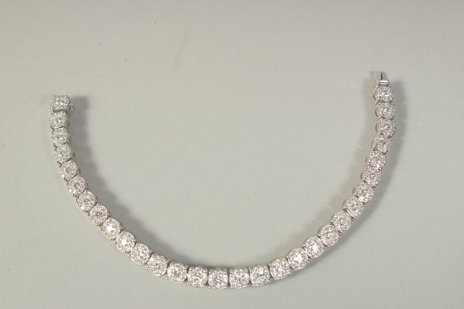 A SUPERB 18 CARAT WHITE GOLD ILLUSION SET DIAMOND LINE BRACELET with 30 cluster set diamonds. 20cm - Image 2 of 3