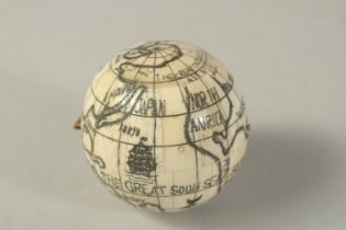 AN ETCHED BONE GLOBE OF THE WORLD COMPASS. 6cms diameter.
