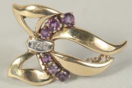A 9CT GOLD AMETHYST AND DIAMOND BOW BROOCH