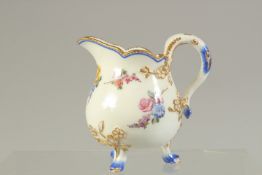 A SEVRES THREE FOOTED JUG painted with flowers.