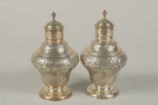 A PAIR OF VICTORIAN SILVER SUGAR CASTERS with repousse decoration and scrolls. London 1909. Maker: