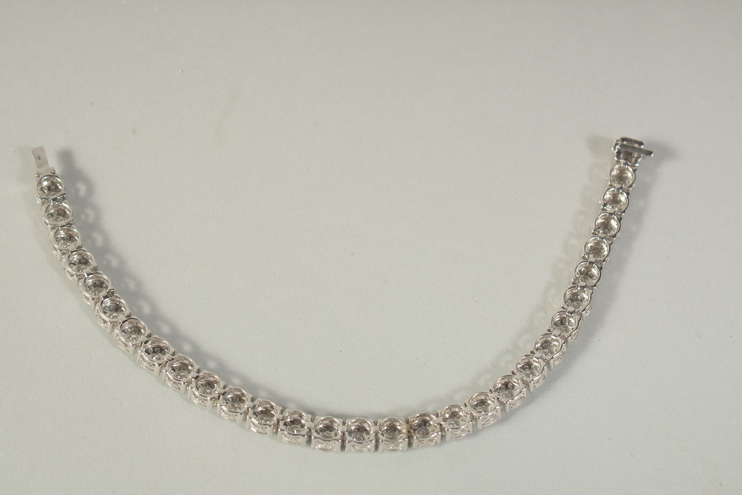 A SUPERB 18 CARAT WHITE GOLD ILLUSION SET DIAMOND LINE BRACELET with 30 cluster set diamonds. 20cm - Image 3 of 3