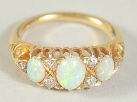 A THREE STONE OPAL AND SIX STONE DIAMOND RING. Size H.