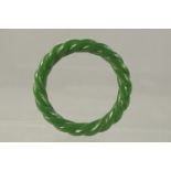 A GREEN JADE TWIST BANGLE. 8cms.