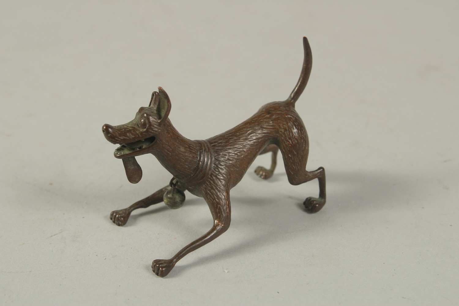 A BRONZE OKIMONO of a Dog. 6cms long.