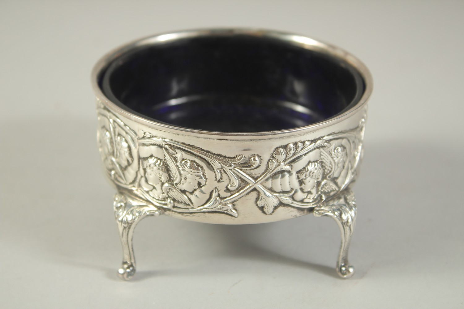 A GOOD LARGE SILVER CIRCULAR SALT with sapphire blue liner repousse side with cupids, supported on - Bild 3 aus 6