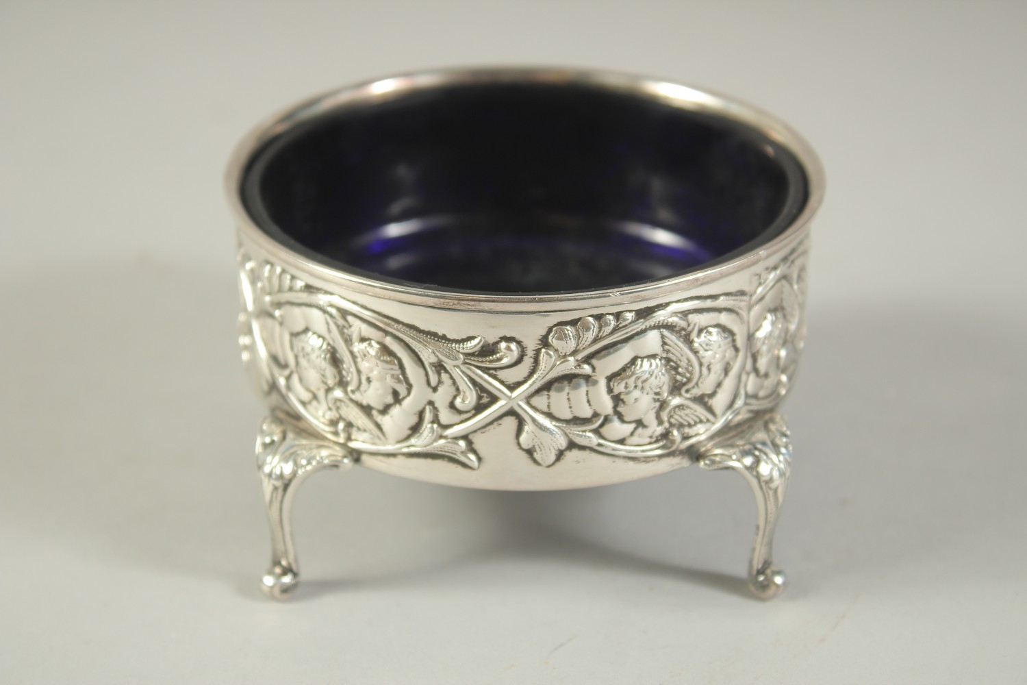 A GOOD LARGE SILVER CIRCULAR SALT with sapphire blue liner repousse side with cupids, supported on - Bild 4 aus 6
