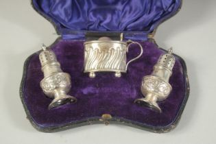 A THREE PIECE CONDIMENT SET in a fitted case, mustard, salt and pepper. Birmingham 1904.