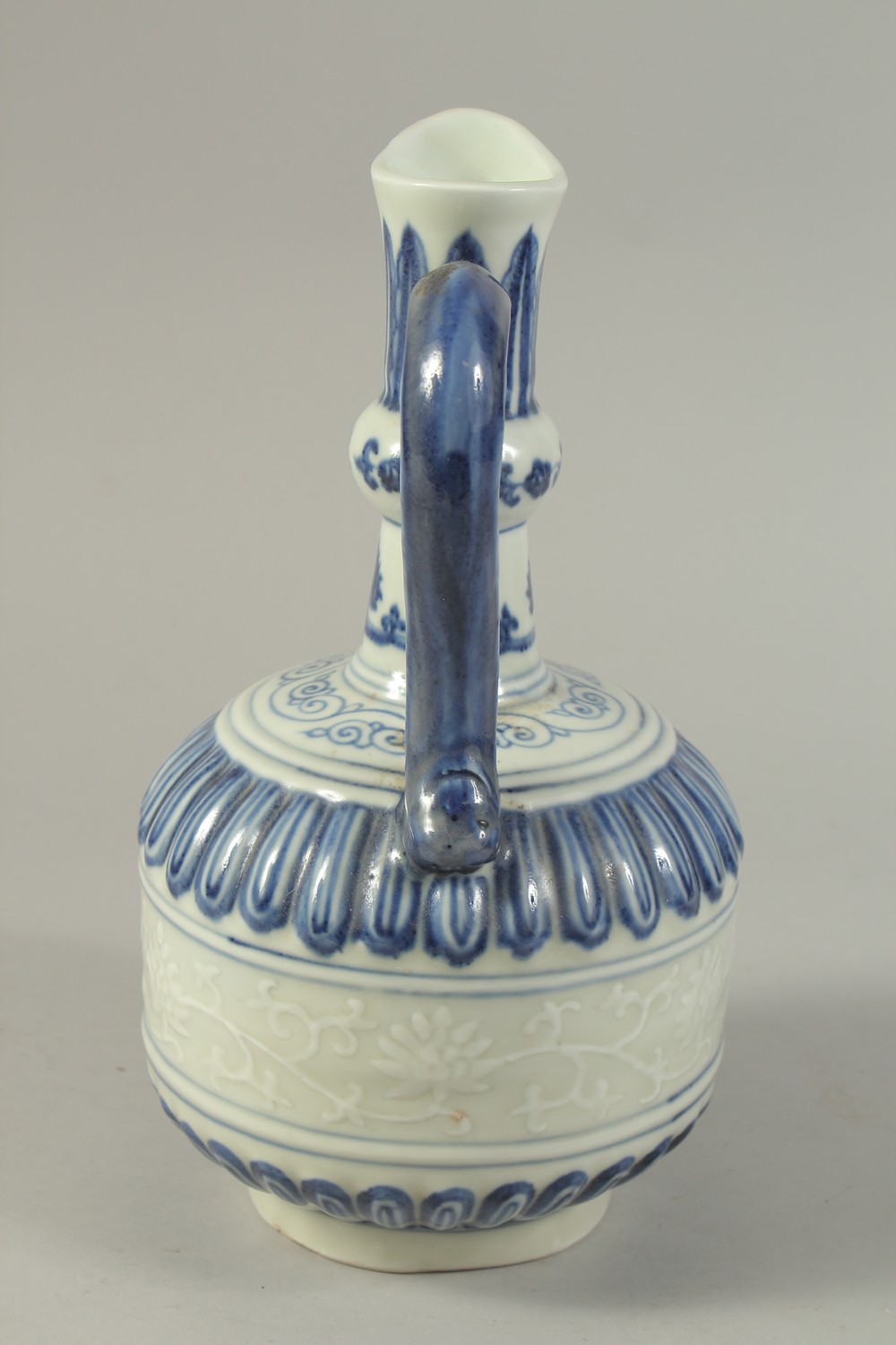 A CHINESE BLUE AND WHITE PORCELAIN EWER, with a band of carved floral decoration. 29cms high. - Image 4 of 6