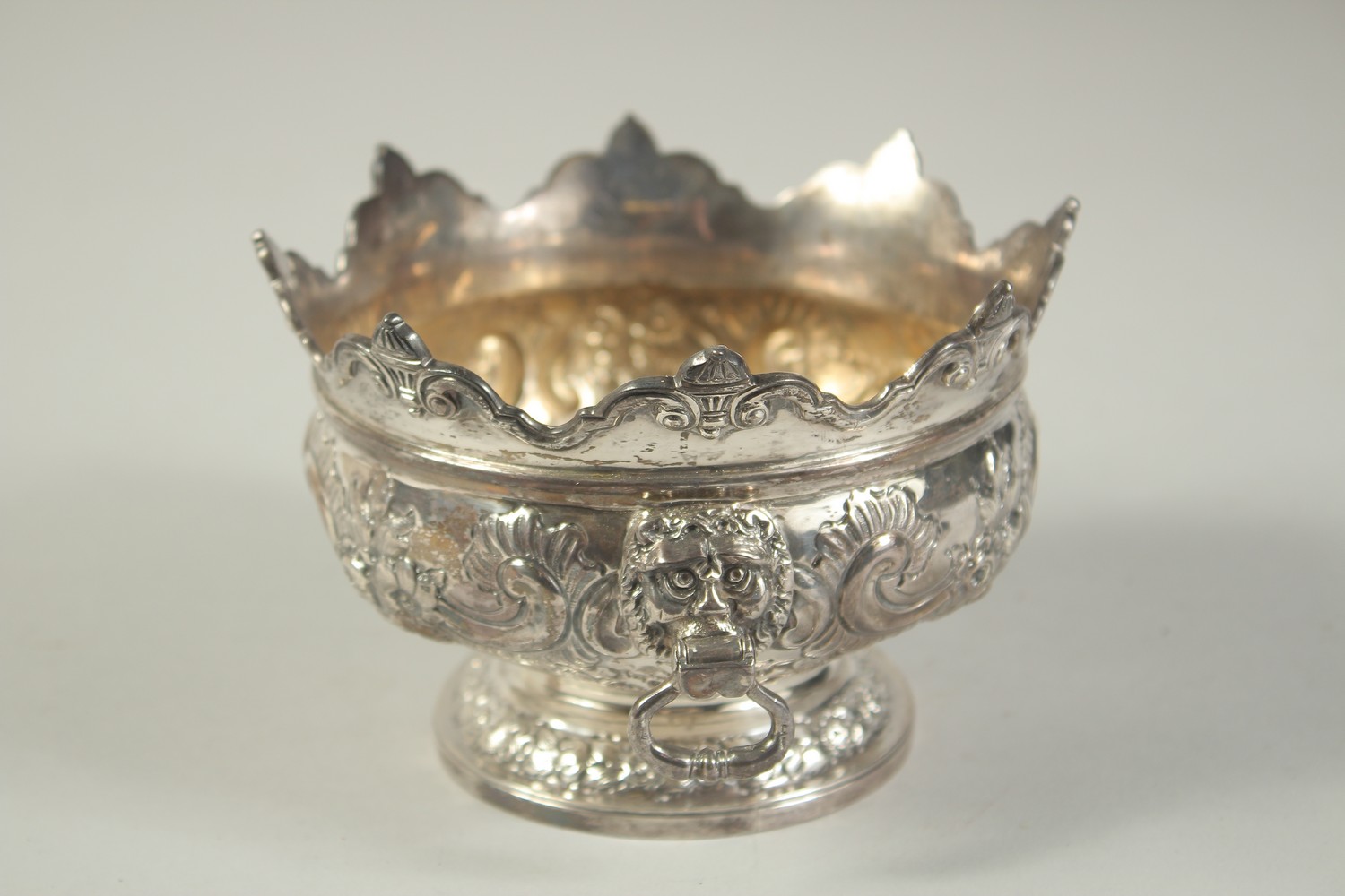 A GOOD SMALL SILVER MONTEITH BOX with repousse decoration and lion ring handles. 5.25ins diameter. - Image 4 of 7