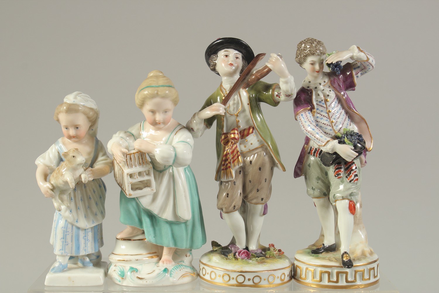 FOUR CONTINENTAL FIGURES, two Rudolstadt boys, one with a violin and another with grapes, and two