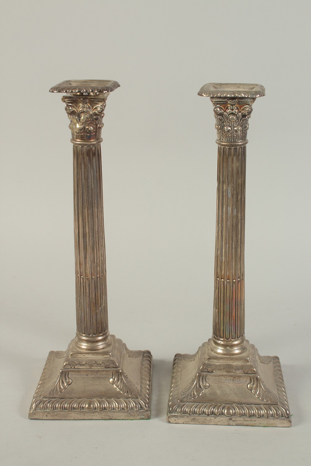 A GOOD PAIR OF VICTORIAN SILVER CORINTHIAN COLUMN CANDLESTICKS on square loaded bases. 13ins high.