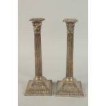 A GOOD PAIR OF VICTORIAN SILVER CORINTHIAN COLUMN CANDLESTICKS on square loaded bases. 13ins high.