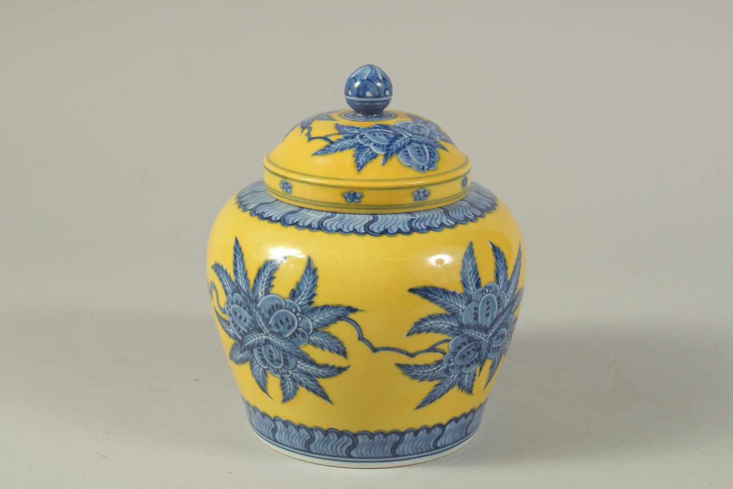 A CHINESE YELLOW GROUND BLUE AND WHITE PORCELAIN JAR AND COVER. 17cms high.