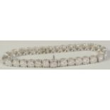 A SUPERB 18 CARAT WHITE GOLD ILLUSION SET DIAMOND LINE BRACELET with 30 cluster set diamonds. 20cm