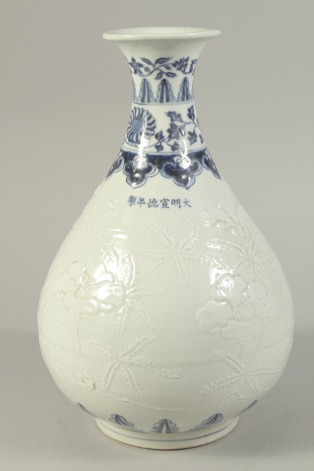 A CHINESE BLUE AND WHITE CARVED FLORAL YUHUCHUNPIN VASE. 32cms high.