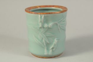 A CHINESE CELADON PORCELAIN BRUSH POT, with gilt characters to the base. 13.5cms high.