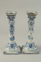 A PAIR OF DUTCH BLUE AND WHITE CANDLESTICKS on square bases. 10ins high.