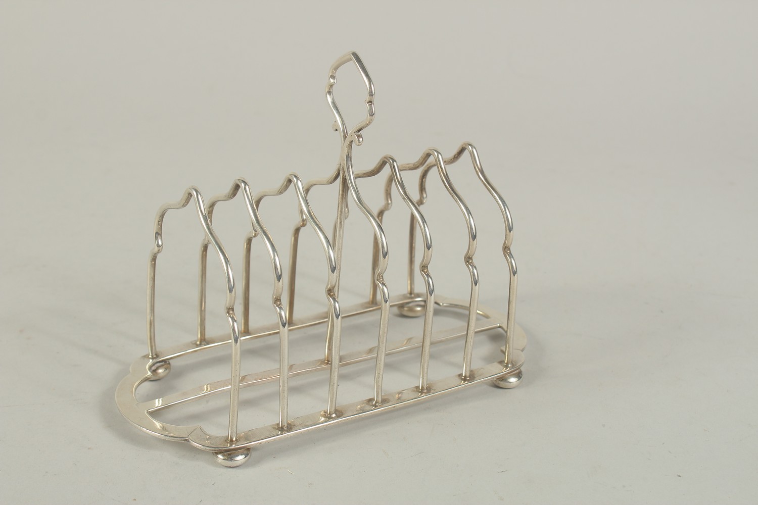 A SIX DIVISION SILVER TOAST RACK on four ball feet. London 1903. Weight: 7ozs. - Image 2 of 3