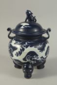 A CHINESE SACRIFICIAL BLUE TRIPOD CENSER AND COVER, the body with incised white dragons. 29cms