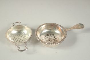 A TWO HANDLED SILVER CIRCULAR STAND AND THE TOP OF A GEORGE III WINE FUNNEL. (2).