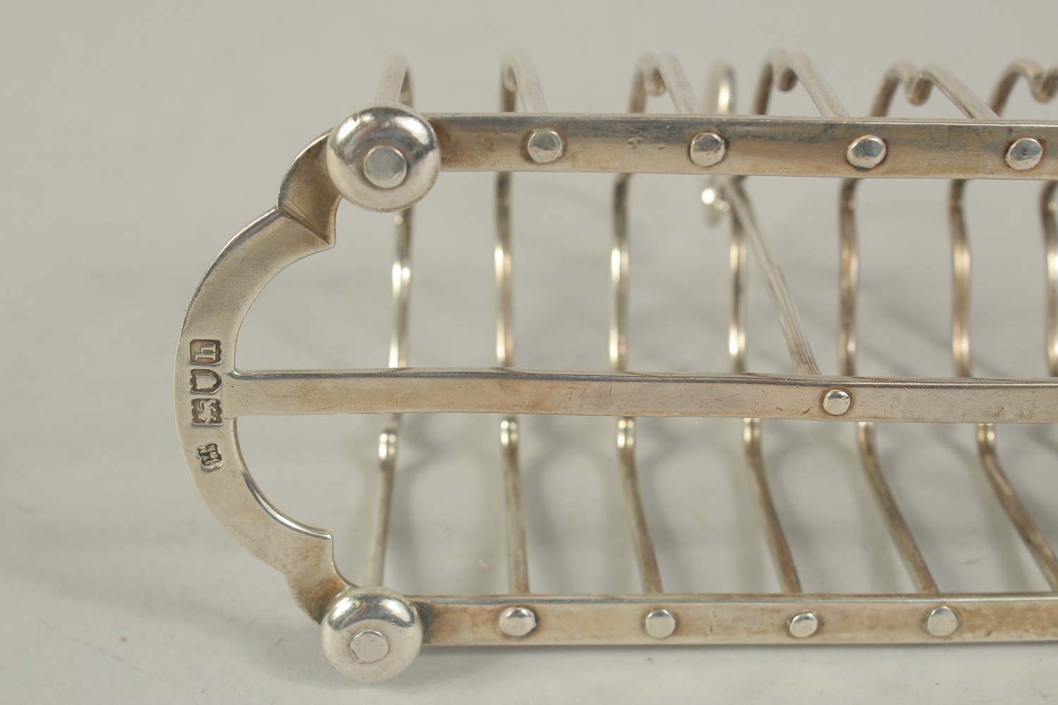 A SIX DIVISION SILVER TOAST RACK on four ball feet. London 1903. Weight: 7ozs. - Image 3 of 3