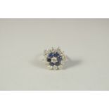 AN 18 CT WHITE GOLD DIAMOND AND SAPPHIRE CLUSTER RING.