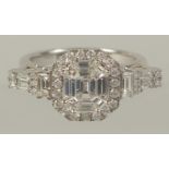 A SUPERB EMERALD CUT DIAMOND CLUSTER RING set in .750 white gold.