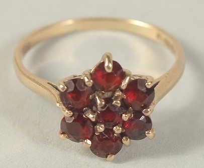 A 9CT GOLD GARNET FLOWER CLUSTER RING