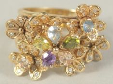 A 14CT GOLD FLOWER CLUSTER RING set with diamond, peridot, amethyst and aquamarine