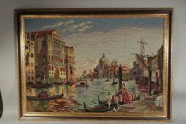 A LARGE GILT FRAMED WOOL WORK PICTURE OF VENICE. 26ins high, 37ins long.
