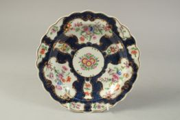 A FINE WORCESTER PLATE, painted with mirror shaped cartouches having exotic birds, on a blue scale