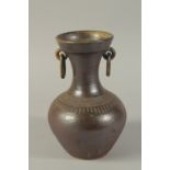 A POTTERY VASE with ring handles. 10ins high.