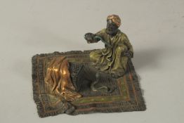 A VIENNA BRONZE SNAKE CHARMER, sitting on a Persian rug. 13cms x 12cms.