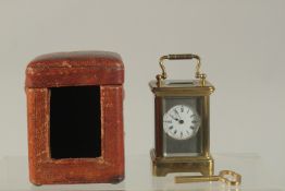 A MINIATURE CARRIAGE CLOCK, 3ins high, in a leather case.