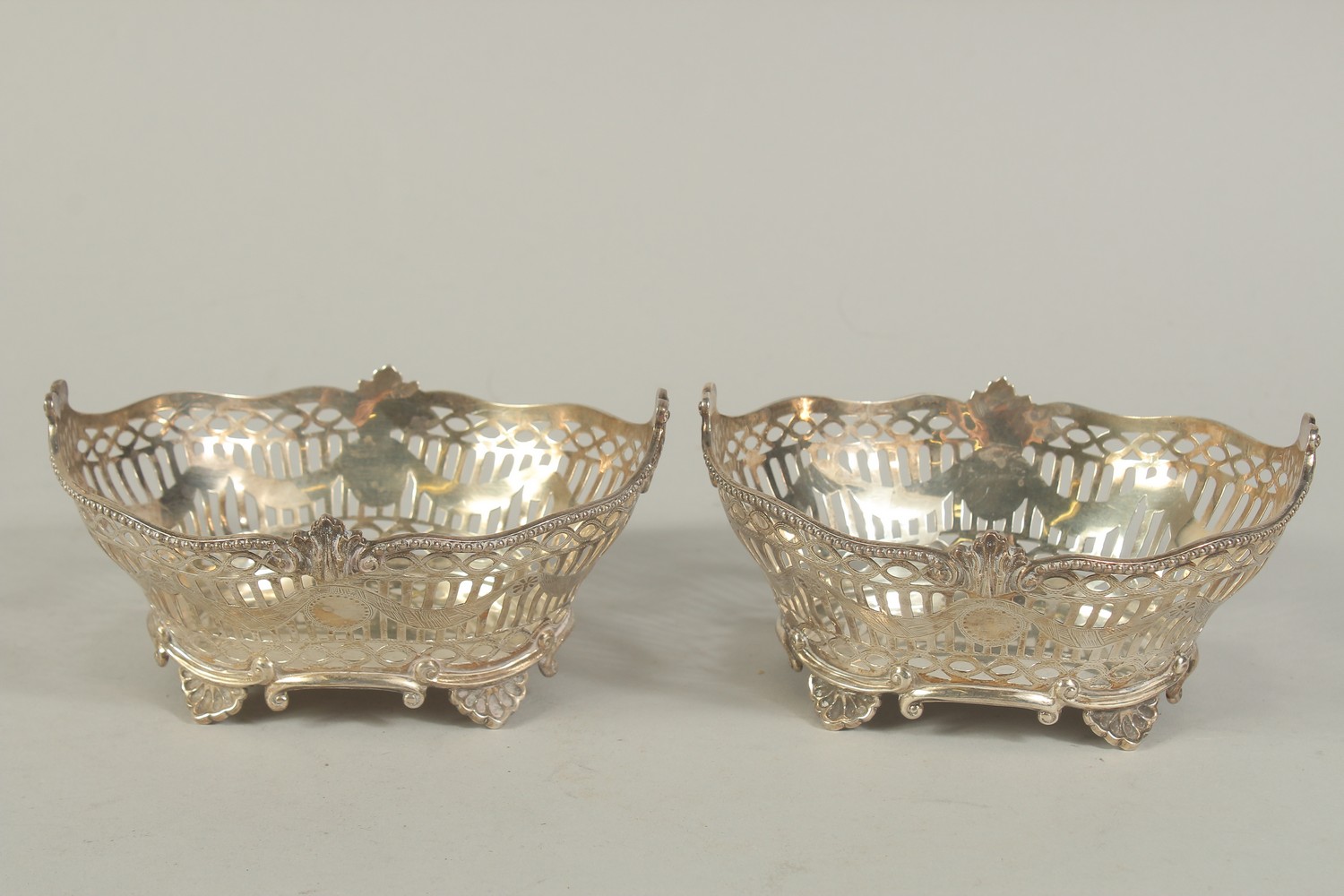 A PAIR OF VICTORIAN SILVER PIERCED OVAL BASKETS with bead edge on four shell feet. 6ins long. London