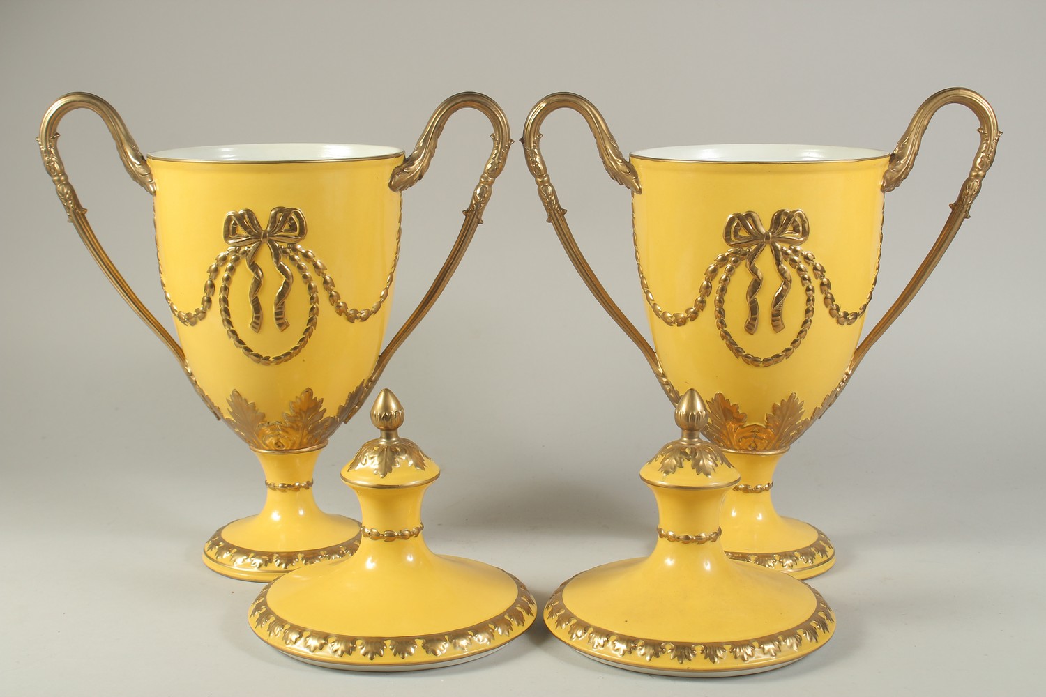 A PAIR OF SEVRES DESIGN YELLOW GROUND TWO-HANDLED URN SHAPED VASES AND COVERS. 17ins high. - Image 2 of 2