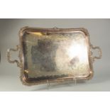 A LARGE PLATE TWO-HANDLED TEA TRAY with gadrooned and shell borders, and scroll handles. 30ins